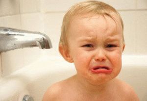 Het kind is bang om in de badkamer te baden