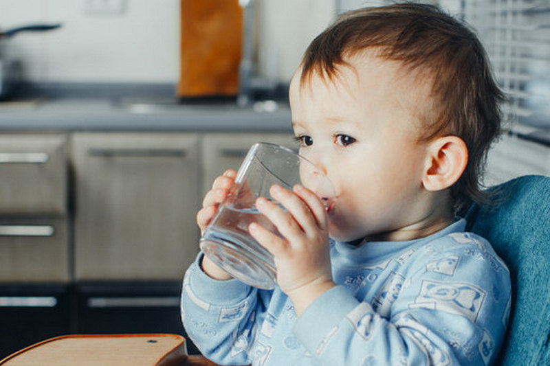 child drinks from a mug