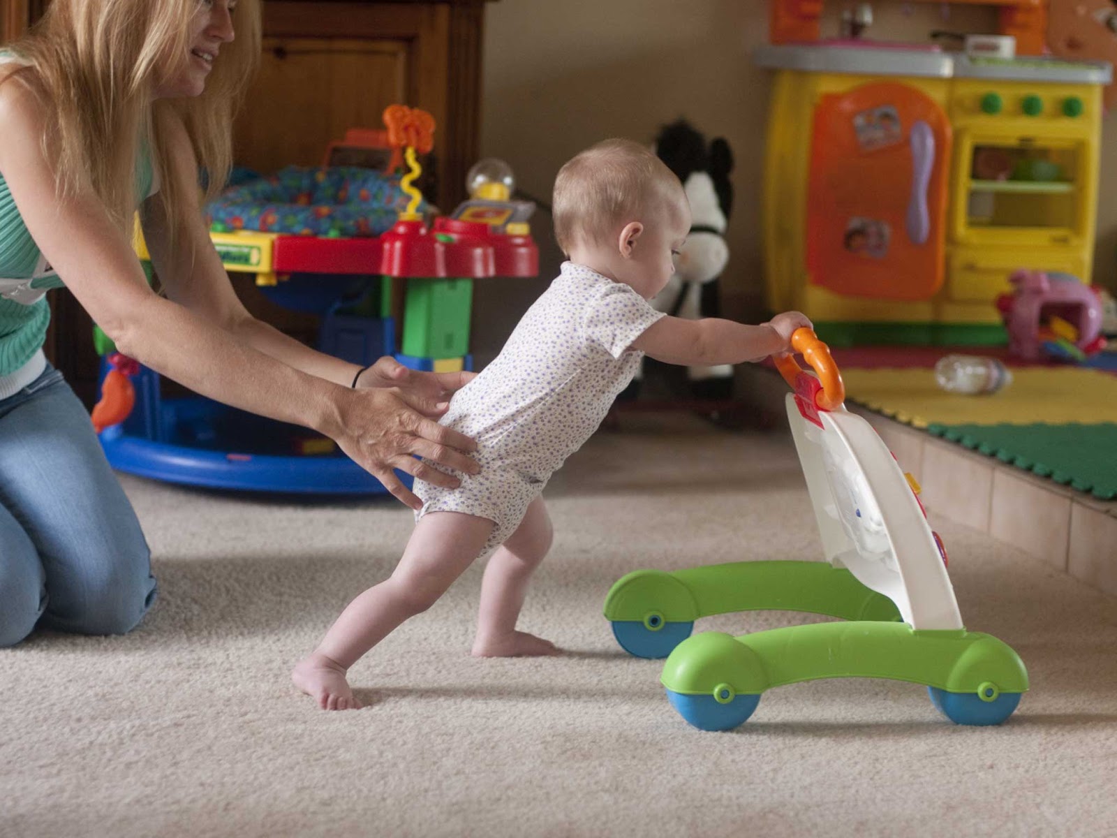 Copil de 10 luni împingând o jucărie