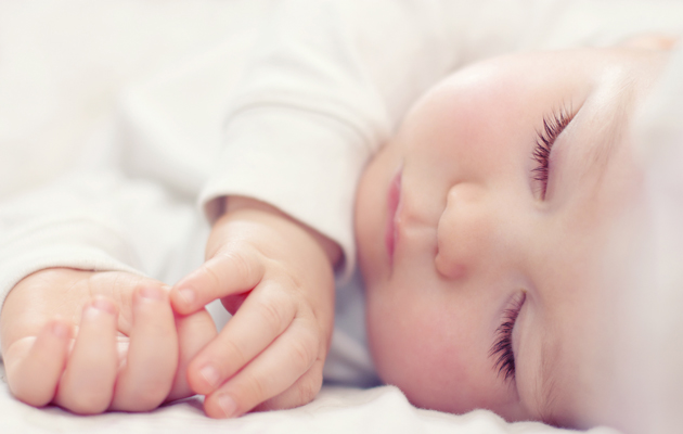 Detailní portrét krásné spící dítě na bílém pozadí
