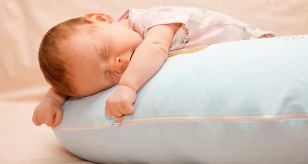 bayi yang baru lahir tidur di atas bantal