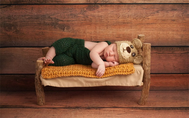 copilul doarme în fotoliul frumos de pătuț