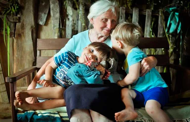 onnellinen isoäiti lastenlasten kanssa